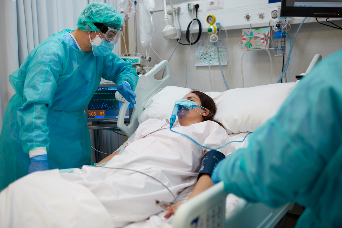 Nurse is comforting a covid patient at the ICU