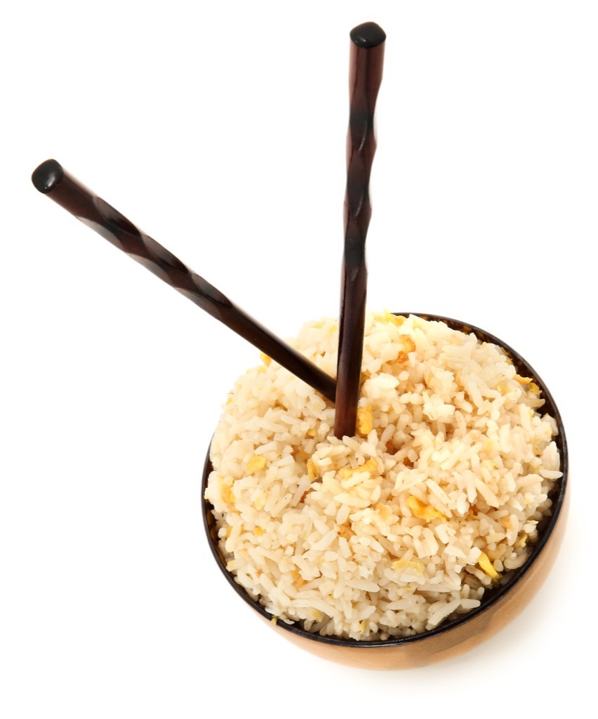 chopsticks sticking upright in a bowl of rice