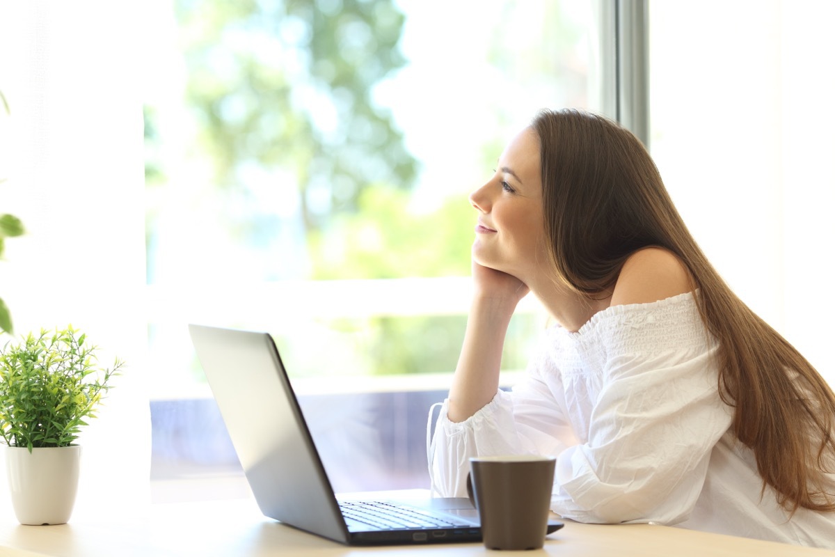 Woman daydreaming looking out her window. 