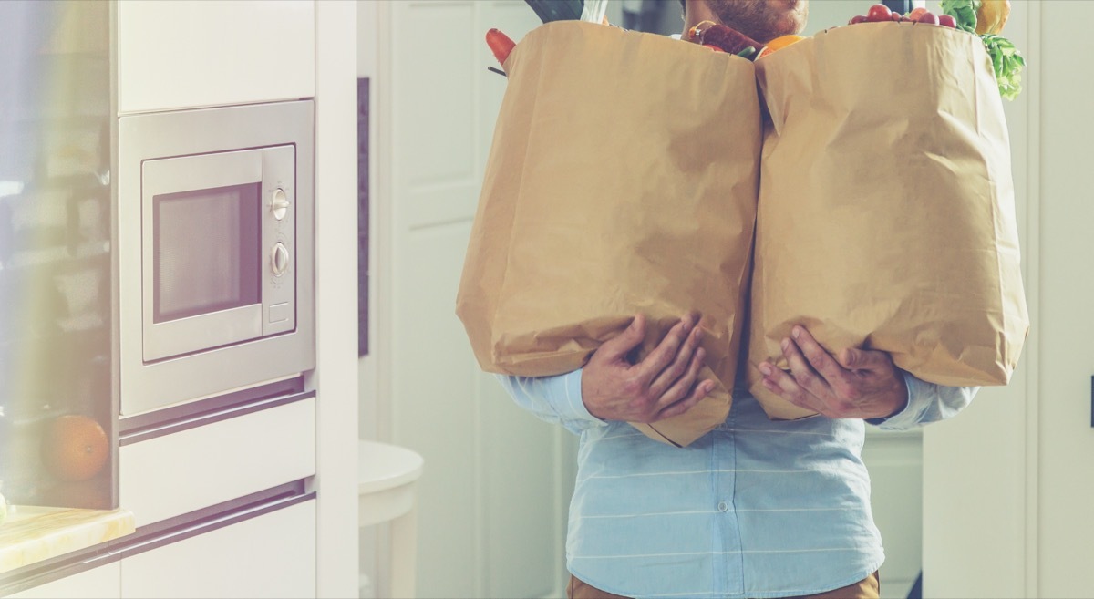 man carrying paper grocery bags