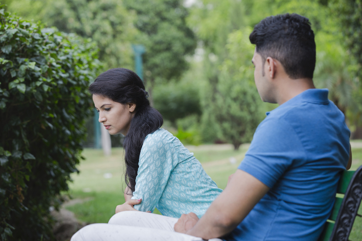 man and woman argue on park bench