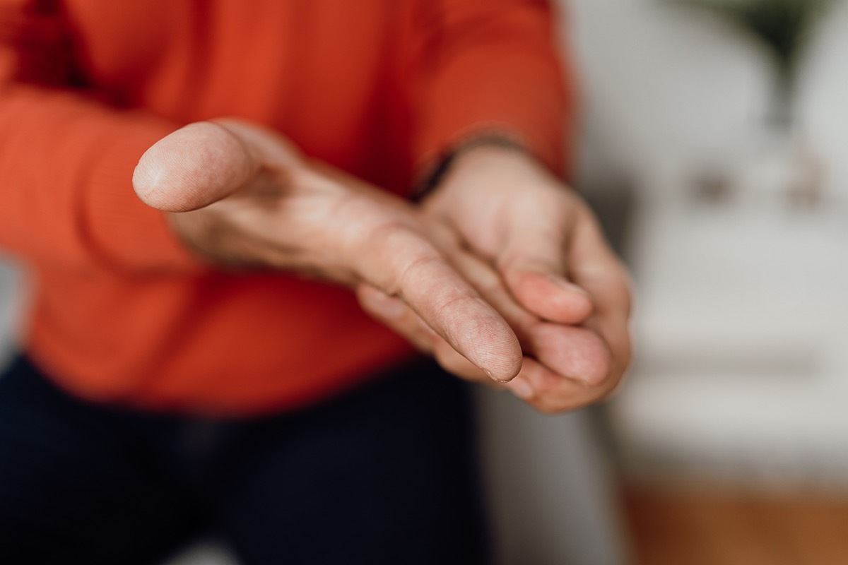 man massaging his hand and fingers