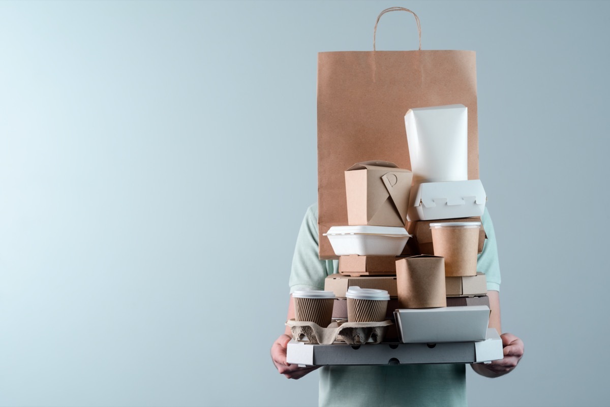 Man holding pile of delivery food