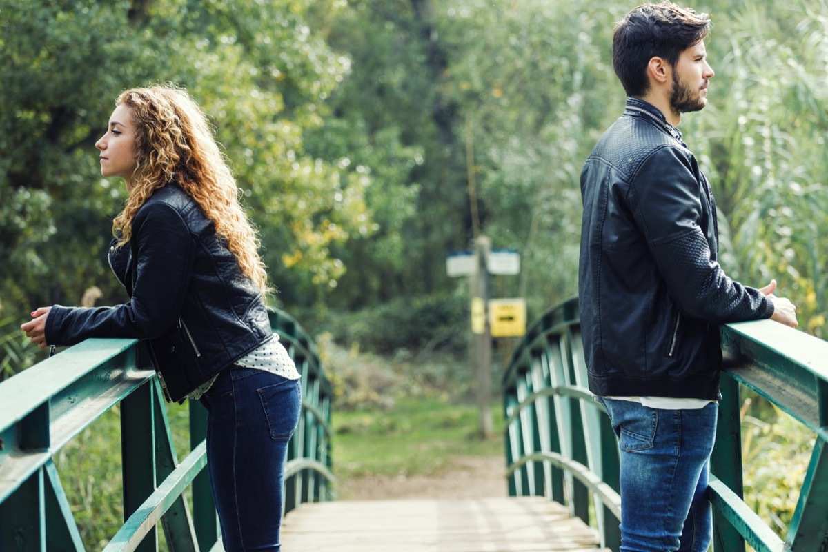 Couple on a bridge keeping distance between them