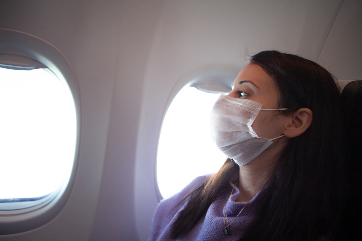 Woman with protective mask in a plane