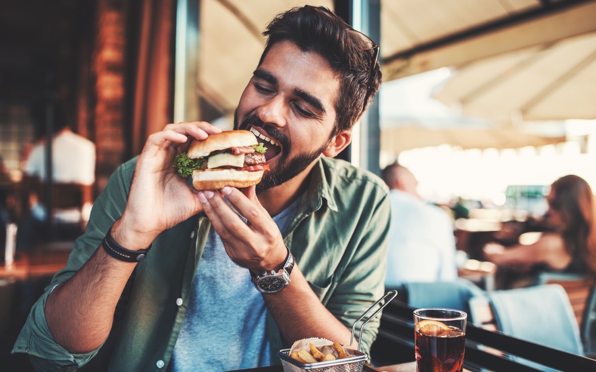 Young man sitting in a cafe and enjoying in breakfast