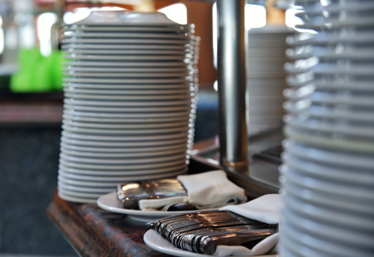 stacks of plates and silverware on a buffet