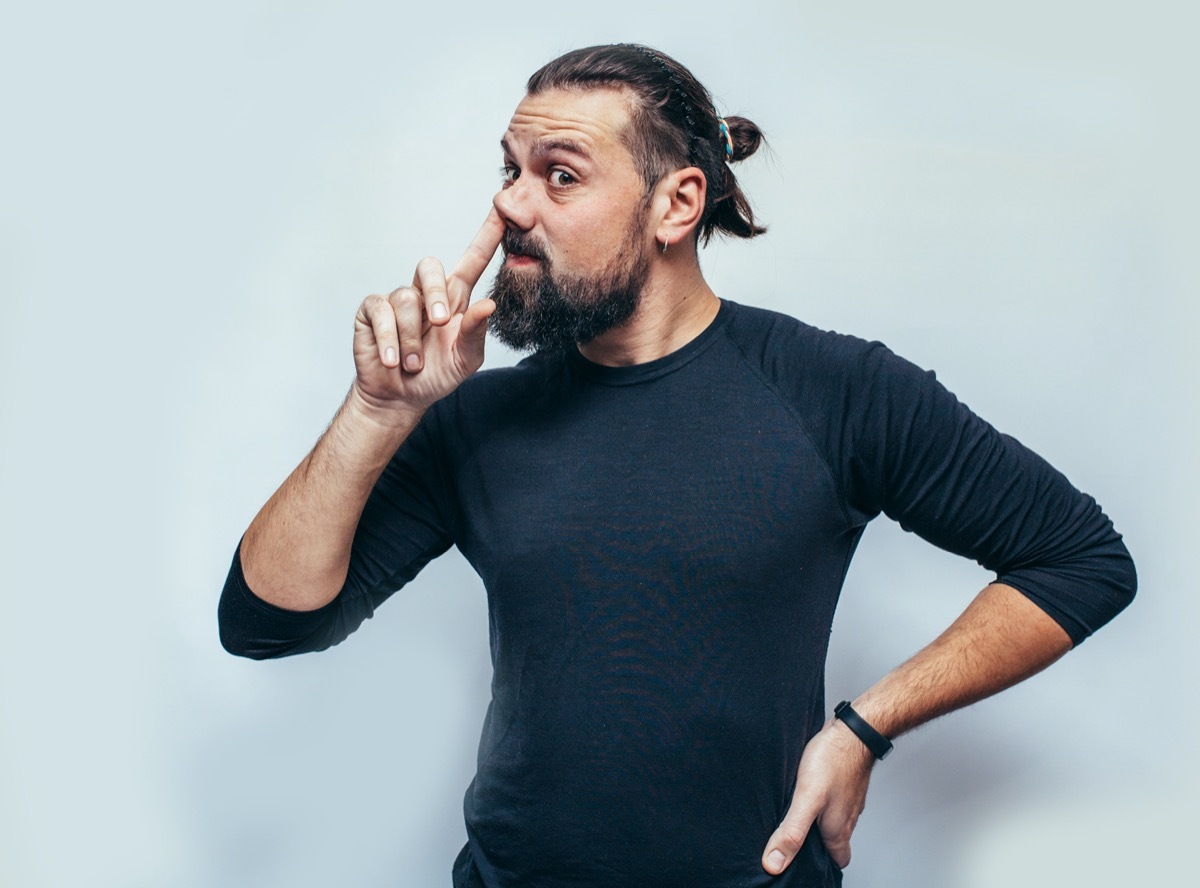 man is emotionally picking his nose