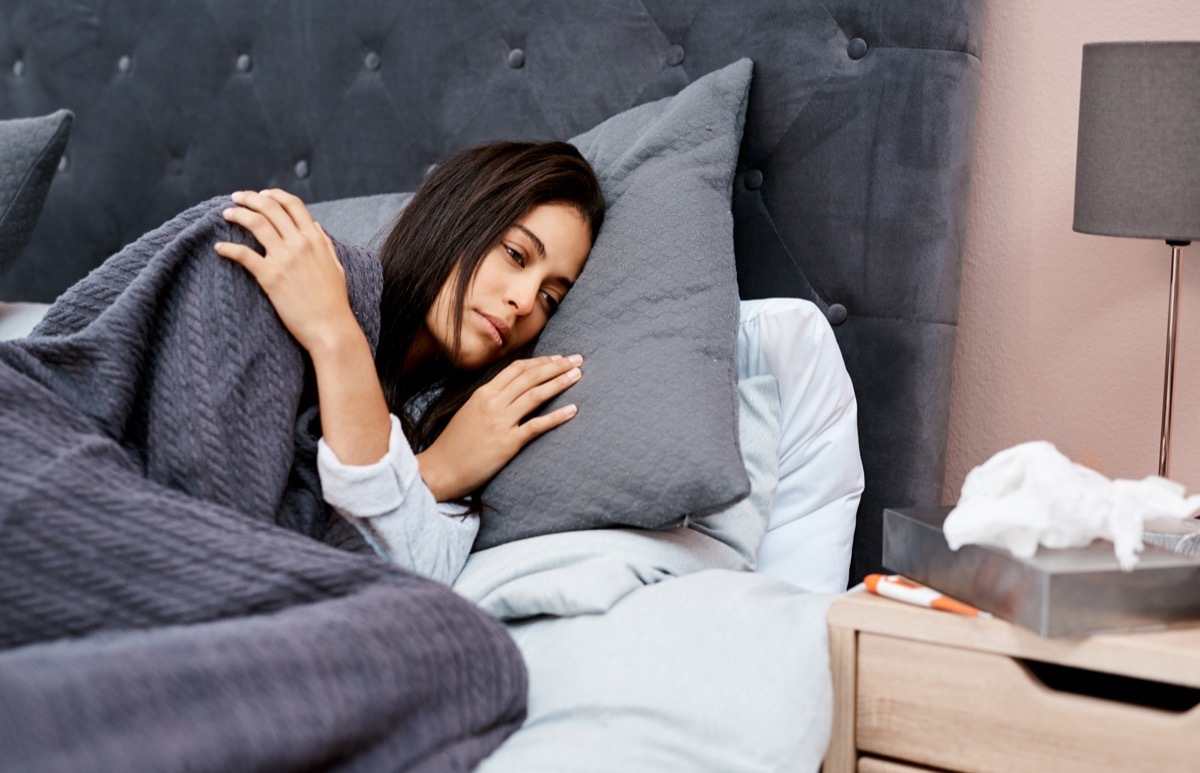 Shot of a young woman recovering from an illness in bed at home