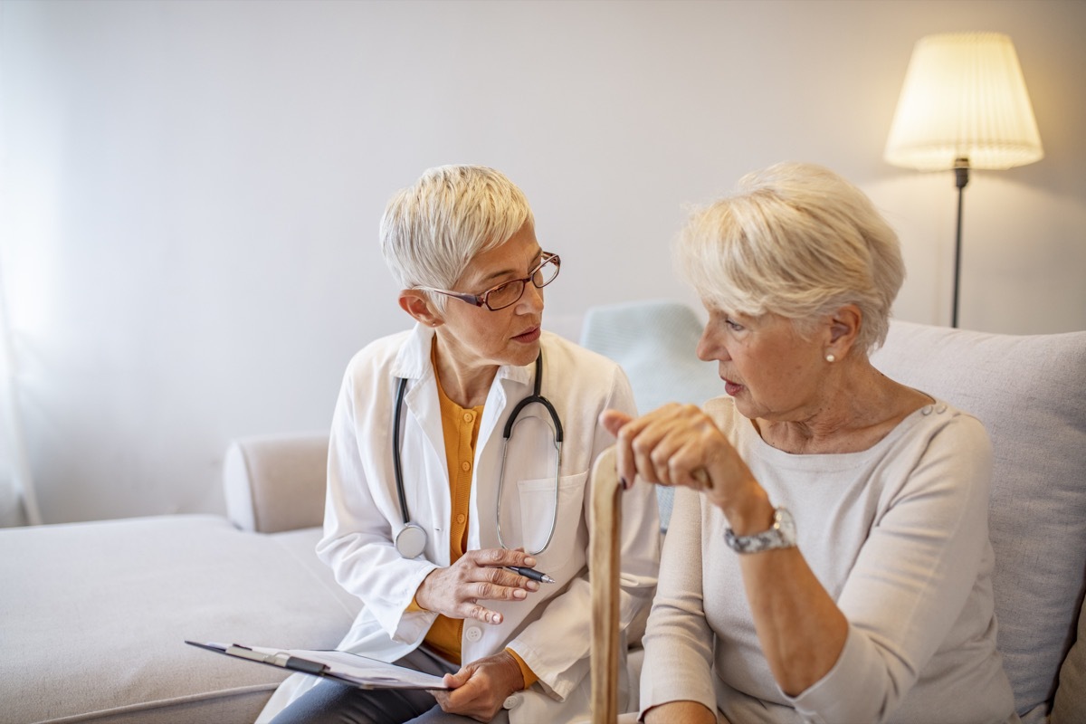 Health visitor and a senior woman during home visit. Female doctor talking to a senior woman. Doctor with senior woman in nursing home. Helpful doctor taking care of senior woman in nursing home