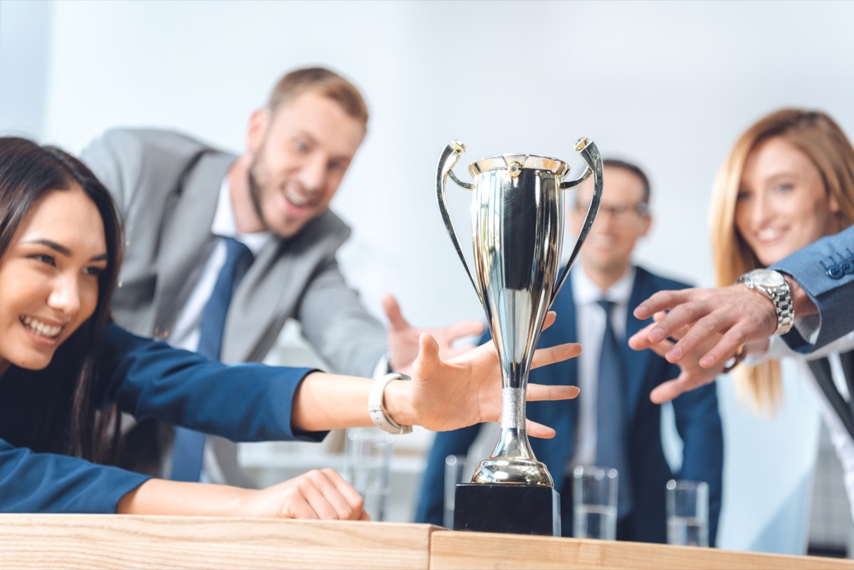 People reaching for a Trophy