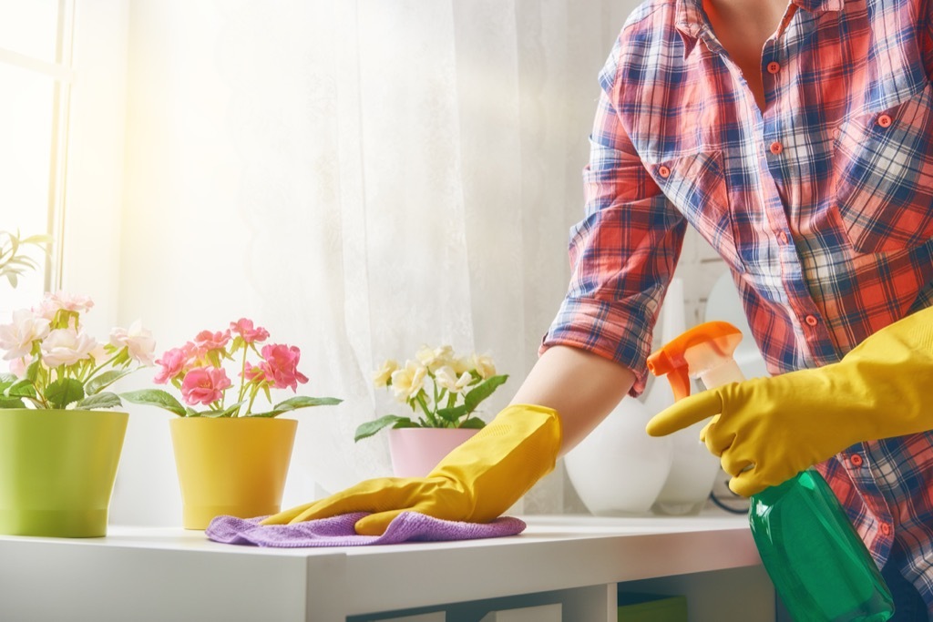 woman dusting countertop, cleaning mistakes