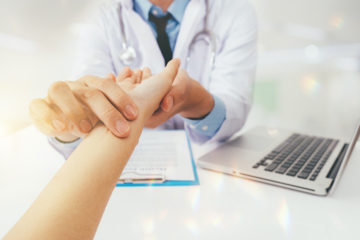 Doctor with patient. Routine health check and holding hands. Male medical doctor with young woman