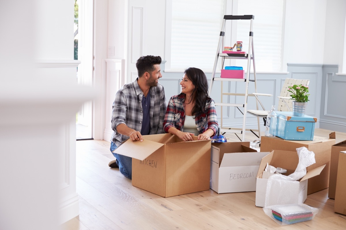 Couple Moving Into New Home And Unpacking Boxes