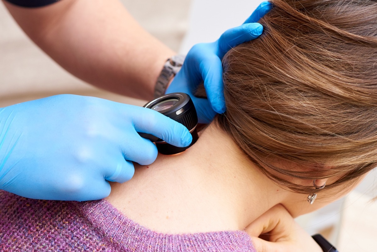 Dermatologist inspecting patient for skin cancer