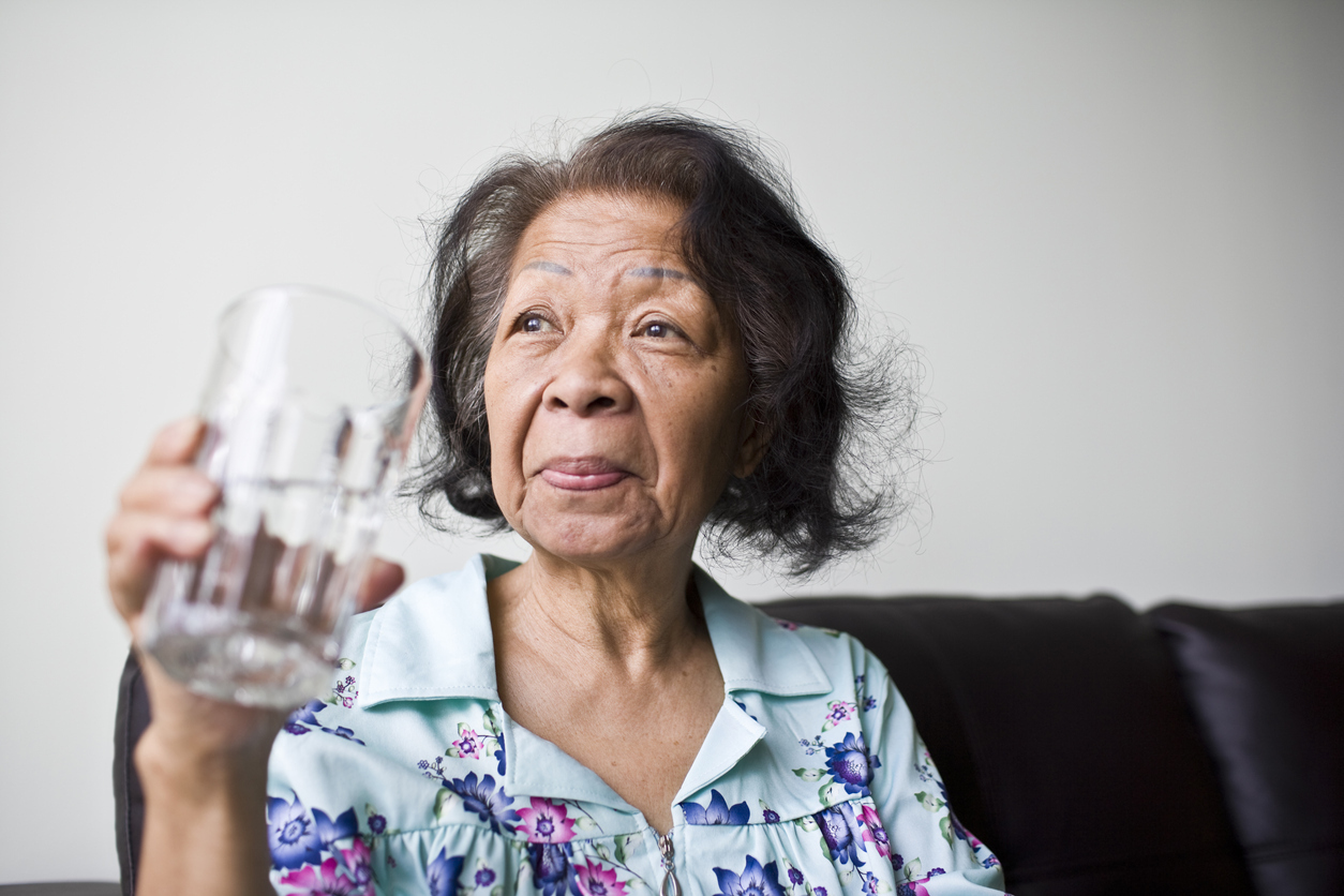 senior Asian Woman with a glass of refreshing water