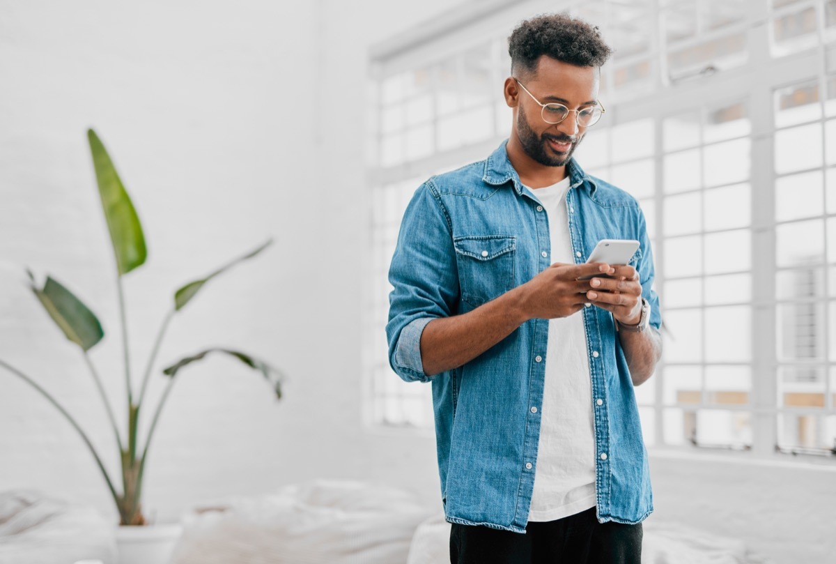 Shot of a young businessman using a smartphone in a modern office