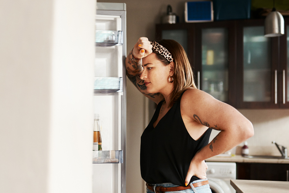 young woman searching inside a refrigerator at home