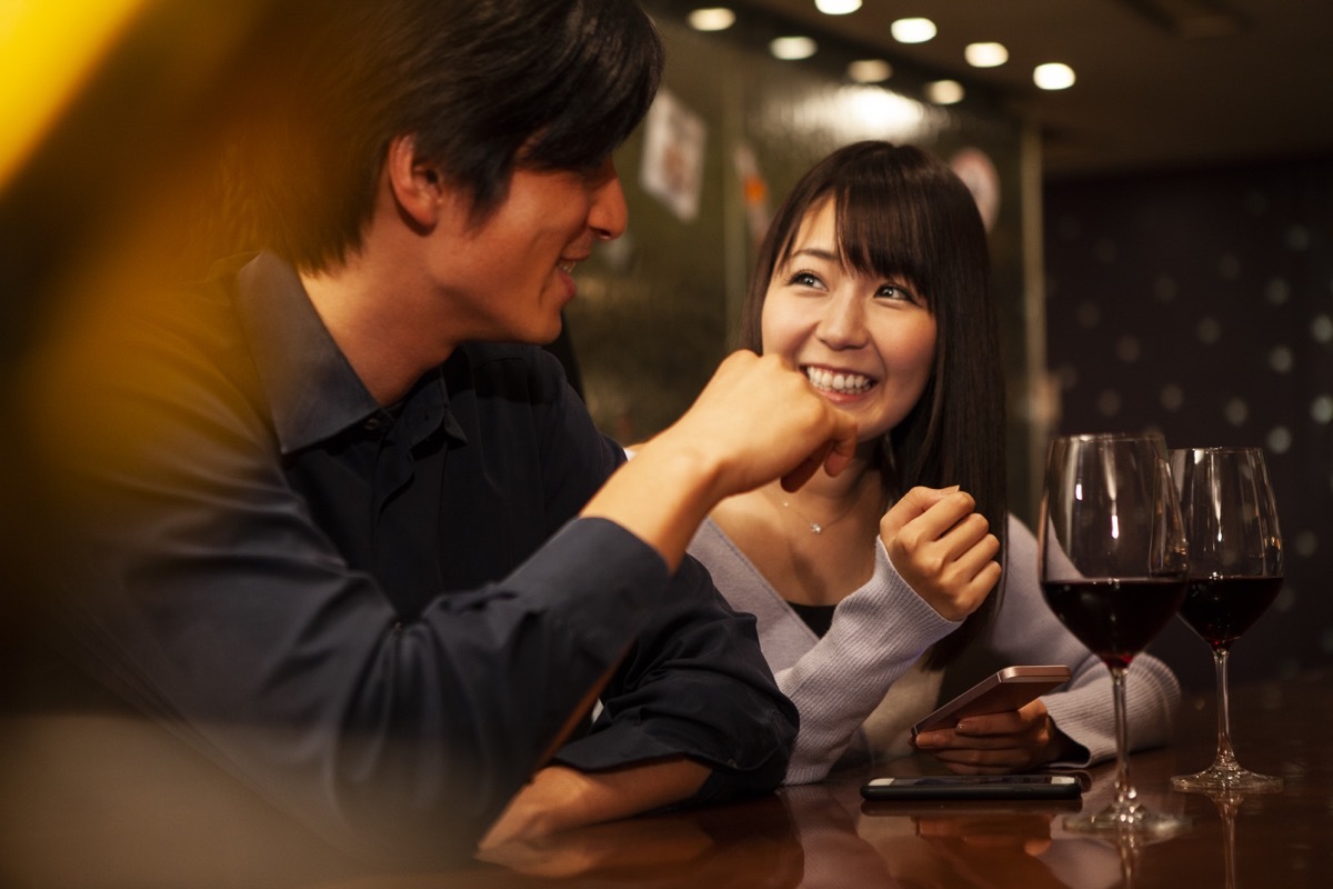 two people on a first date talking over a glass of wine