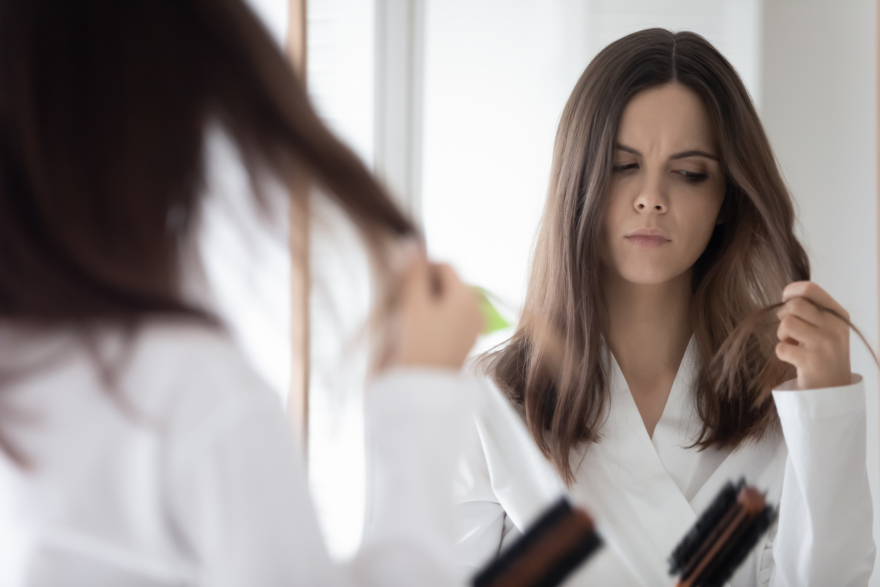 Worried woman brushing her hair.