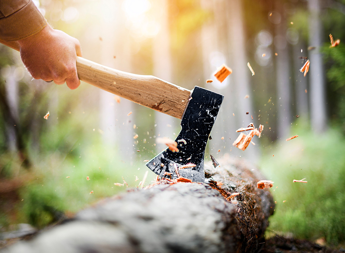 Close up of a man using an axe to chop a log