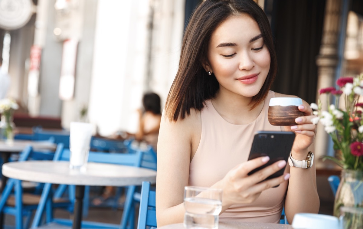 good morning text - woman on phone at cafe