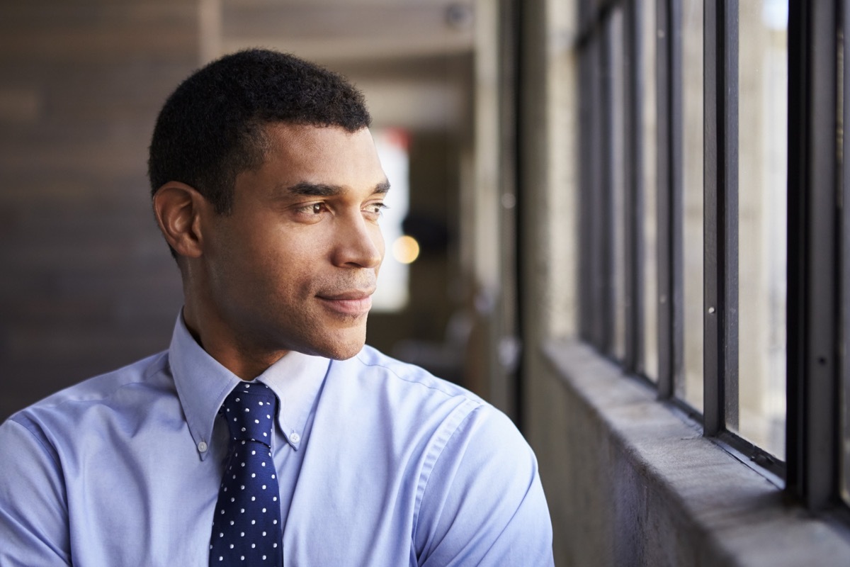 man staring out the window in his office