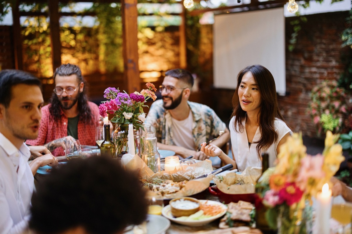 Friends and family having lovely garden dinner party in the summer, autumn