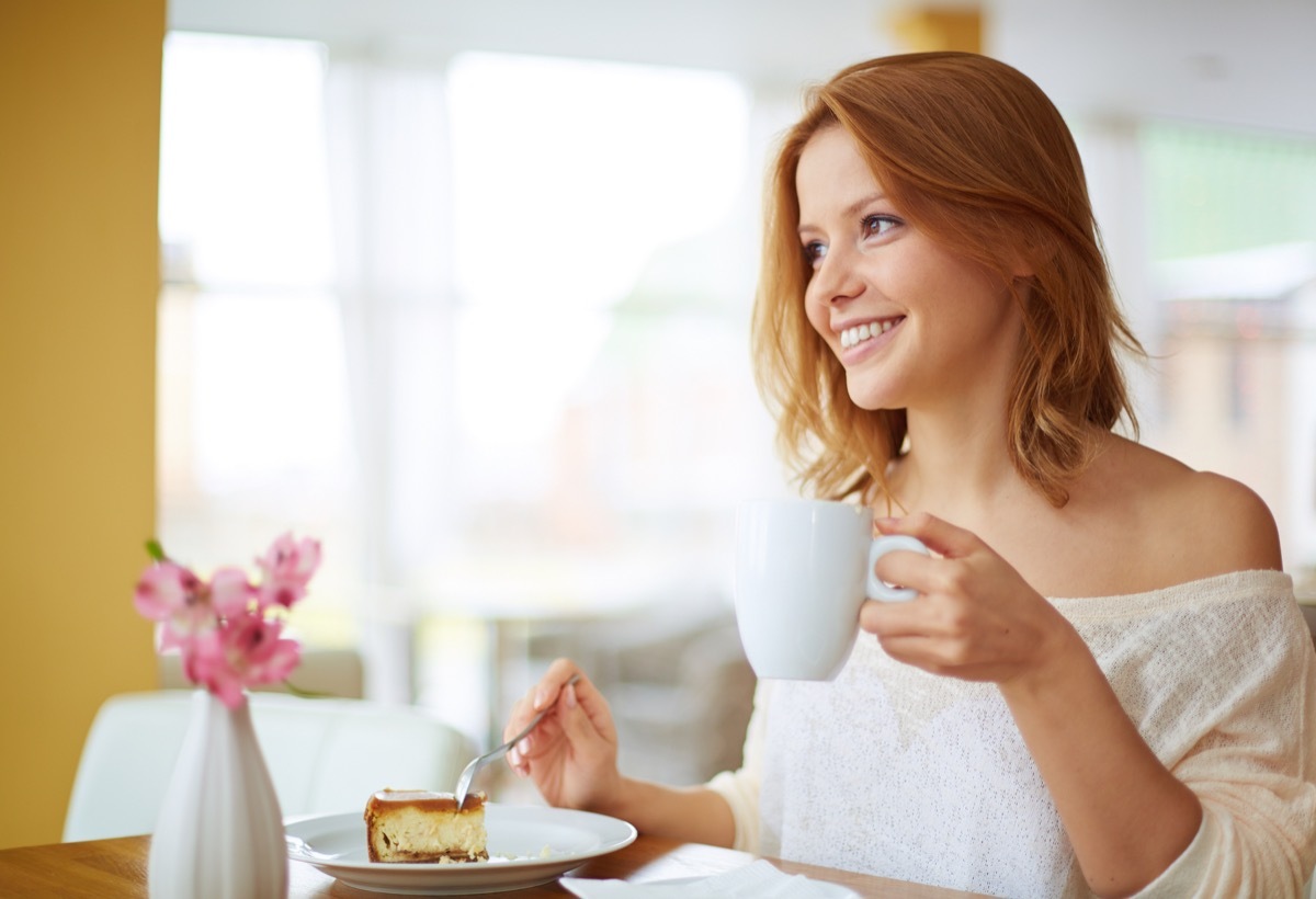 Red-headed woman enjoying a sugary dessert