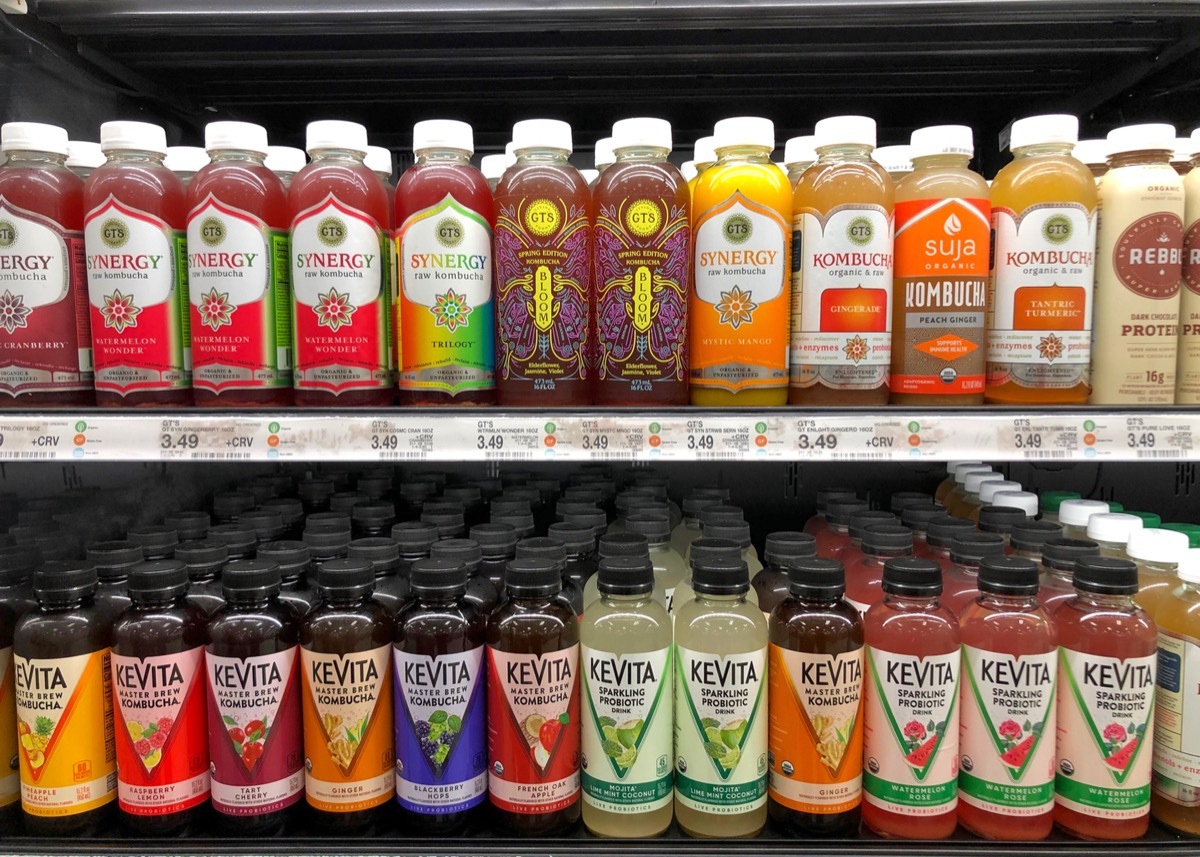 Grocery store shelves with bottles of Kombucha 