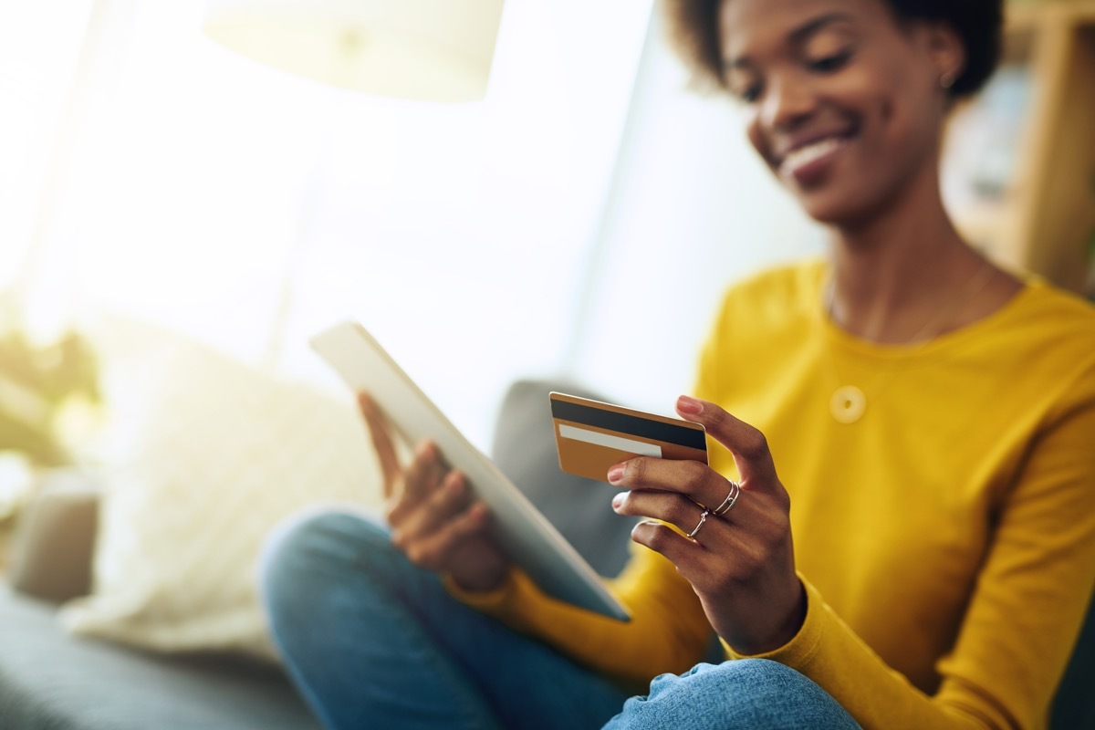 Cropped shot of a young woman using a digital tablet while relaxing at home