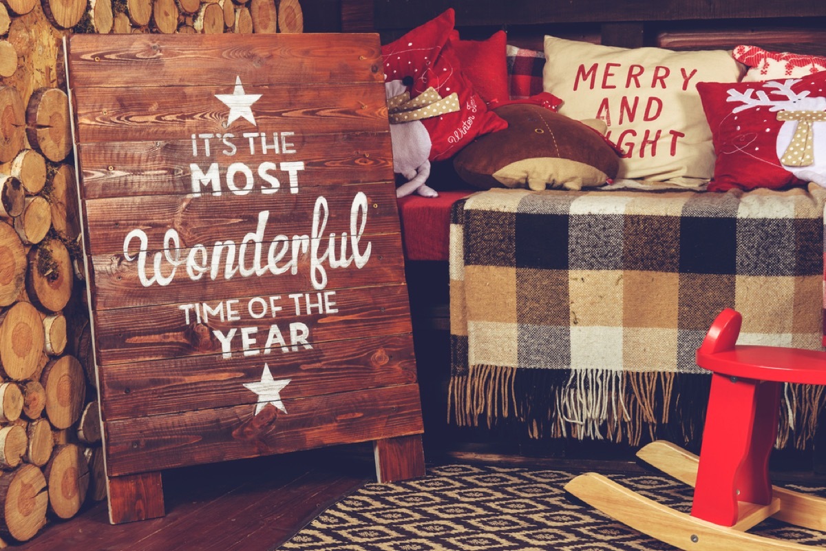 bench with plaid blanket and wooden sign in front of it reading 