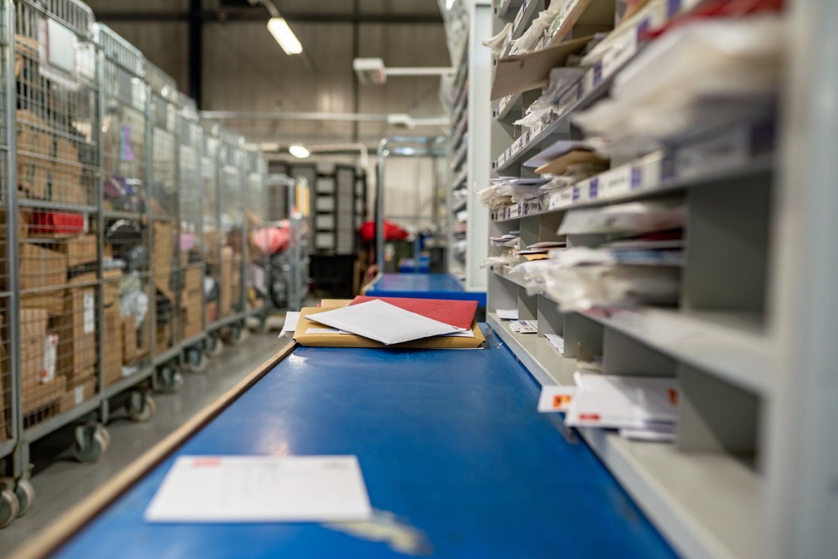 Letters on a sorting frame, table and shelves in a mail delivery sorting centre. Postal service, post office inside