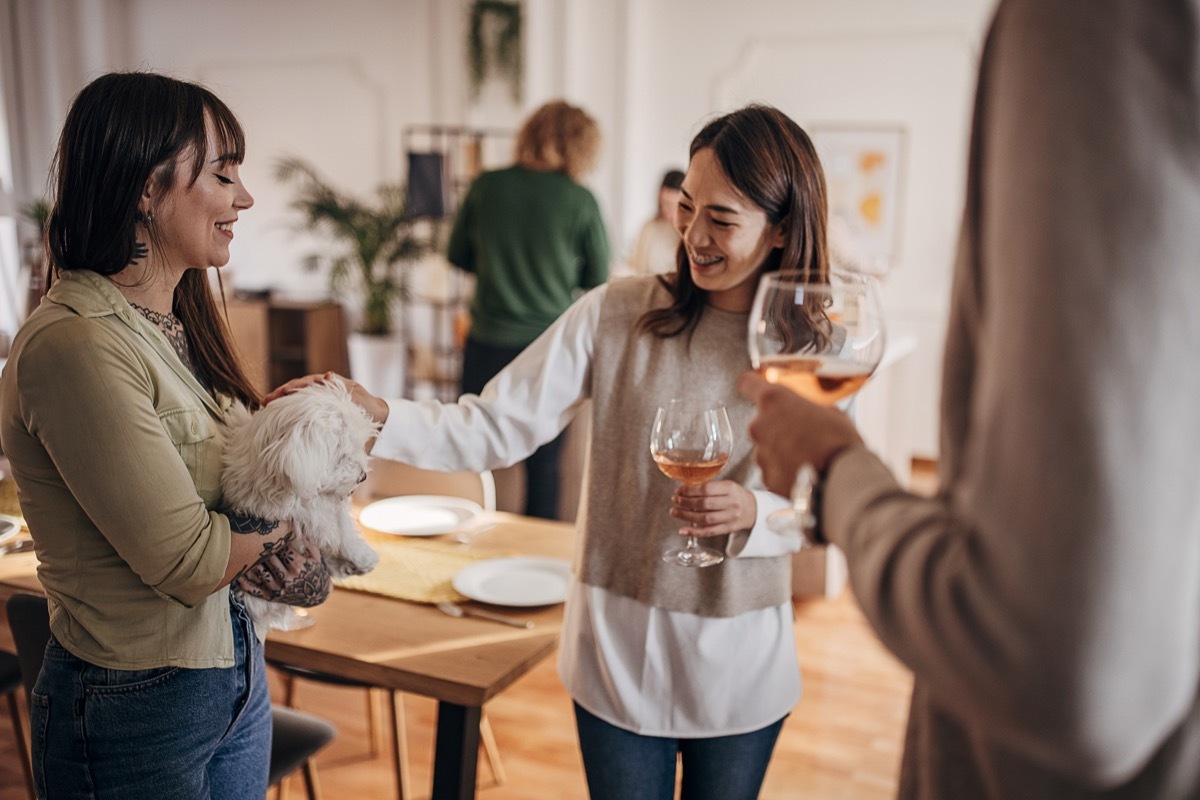 Group of people, diverse male and female friends together on dinner party in modern home,