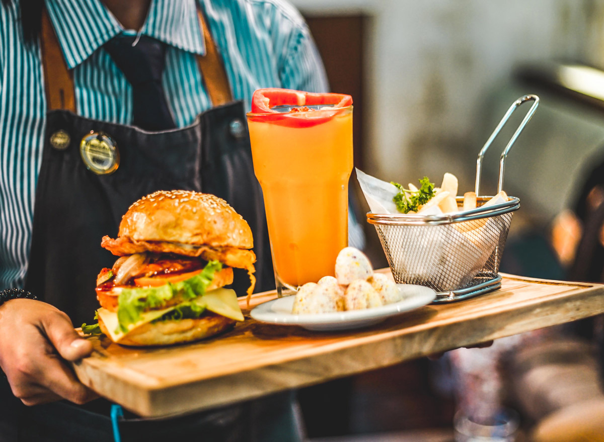 waiter with tray of burger and beer