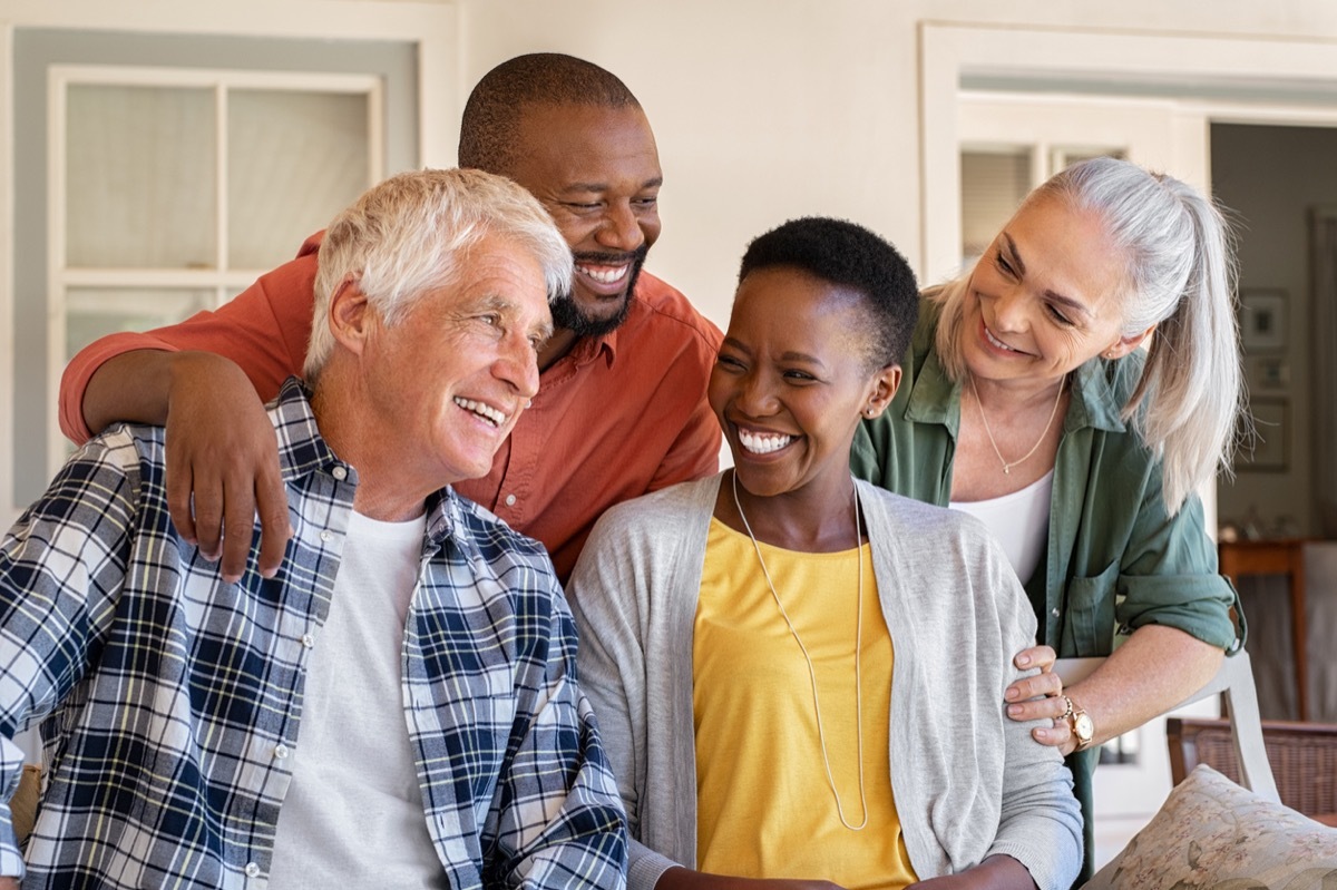 older white couple and older black couple laughing together