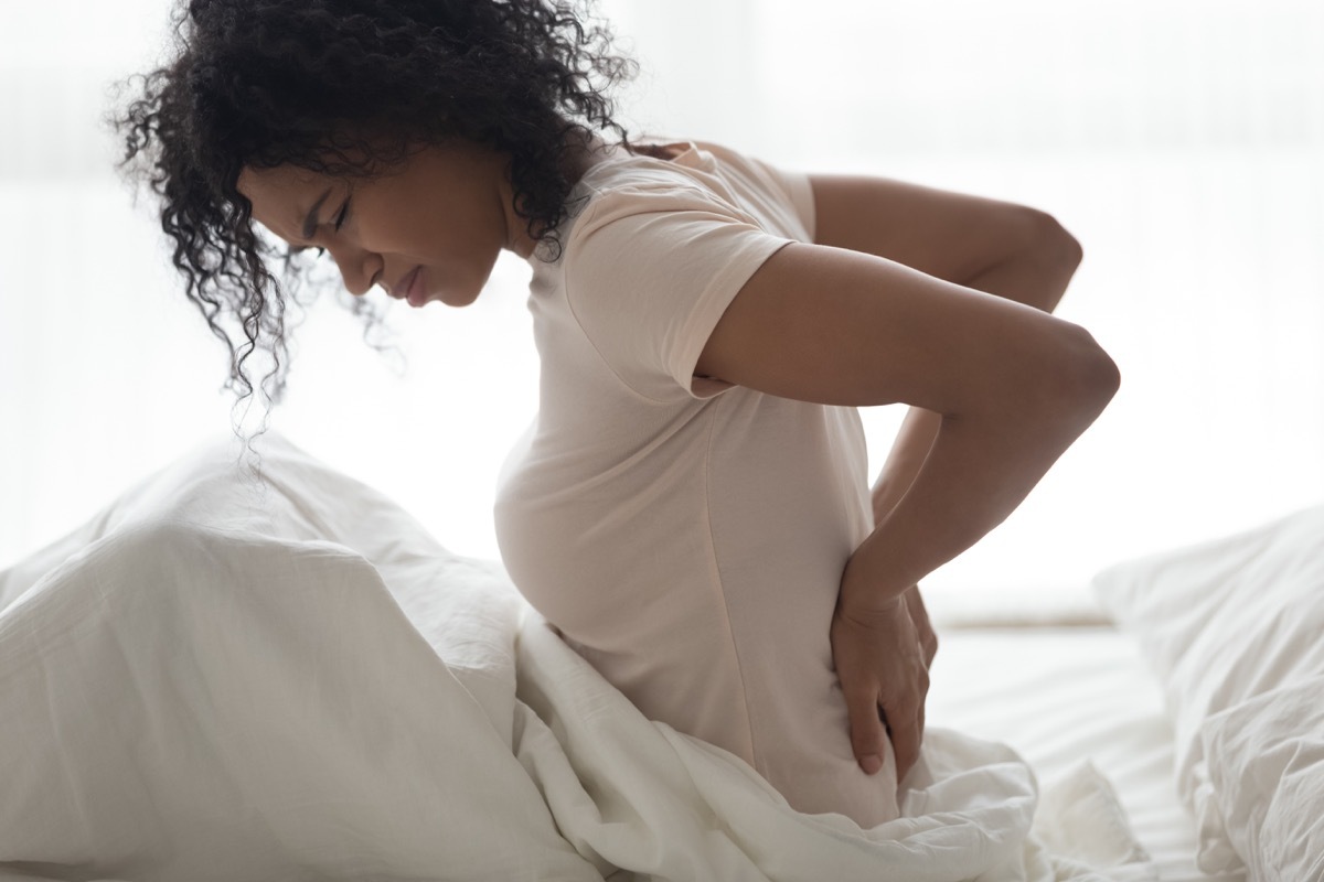 woman touching back feeling backache