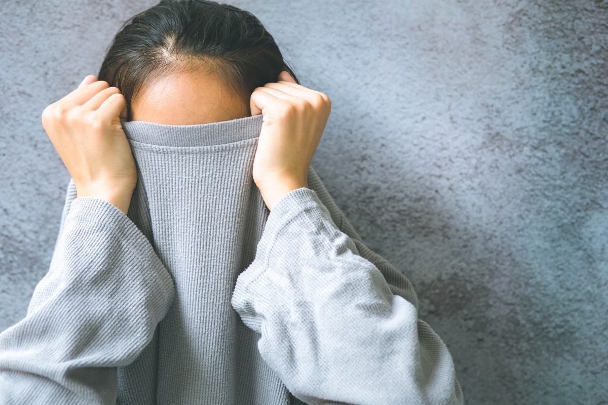 woman hiding her face in shirt to escape from common phobias